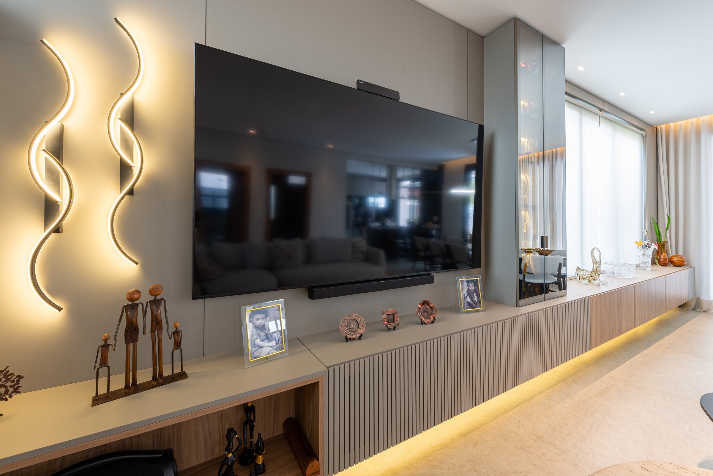 Living com painel de televisão e iluminação embutida na marcenaria