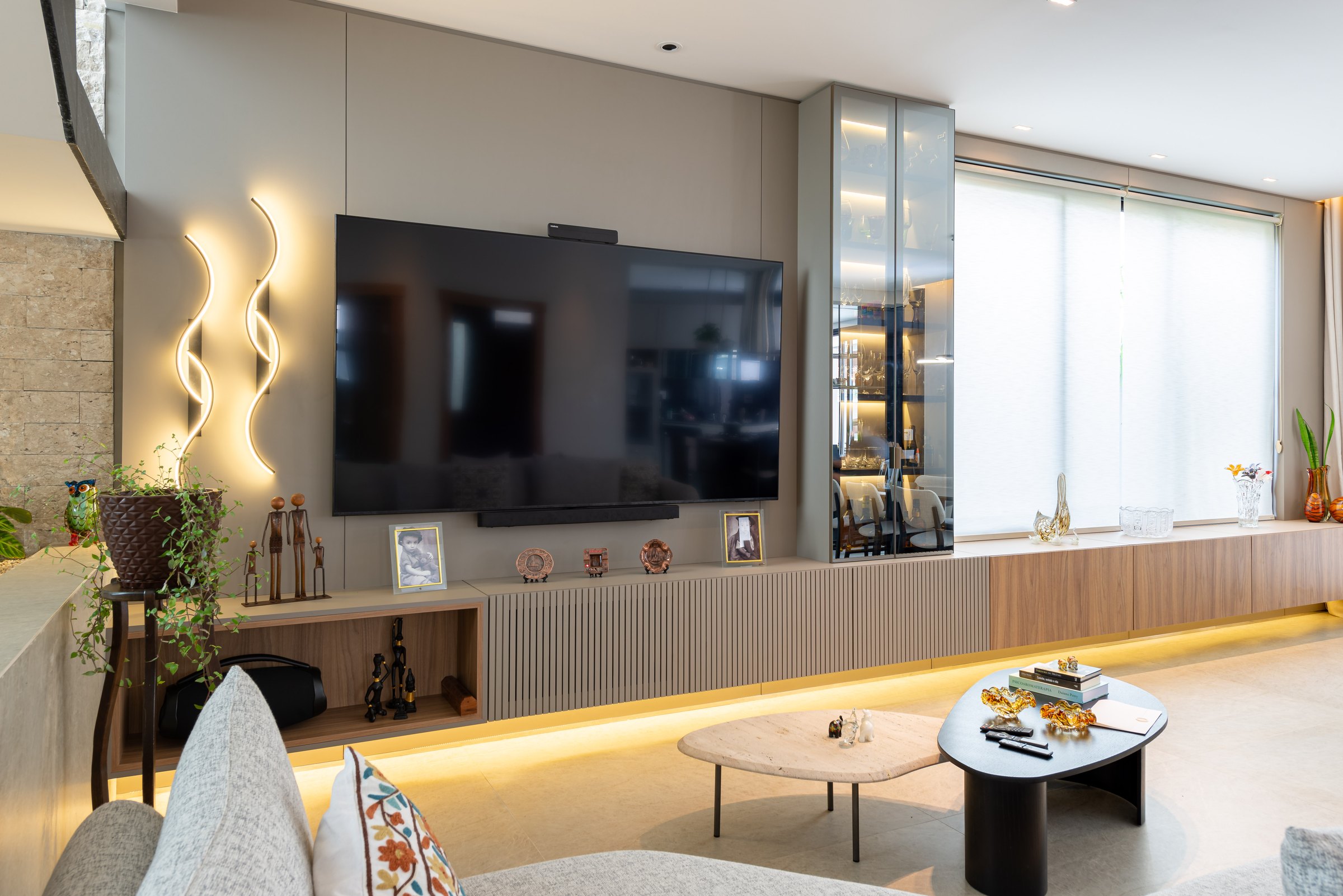 Living planejado com painel de televisão, cristaleira e iluminação integrada